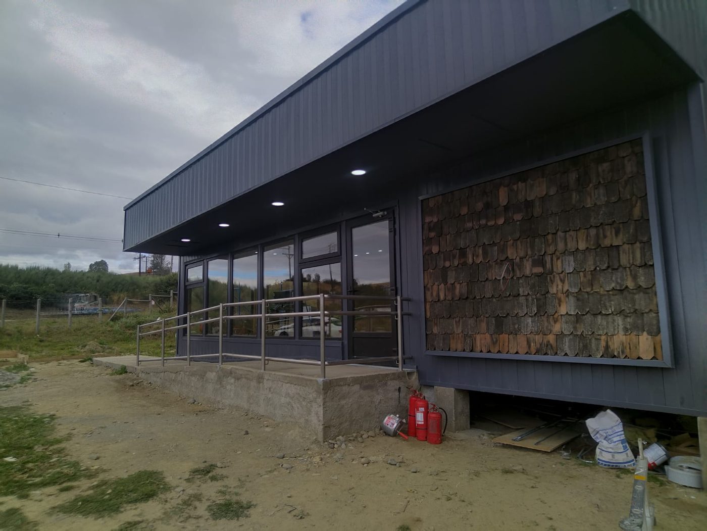 Tienda La Isla Invermar en construcción, con revestimiento de tejuelas a medio instalar